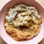 Basmati Rice Pudding with Toasted Coconut Flakes and Maple Syrup in a pink bowl