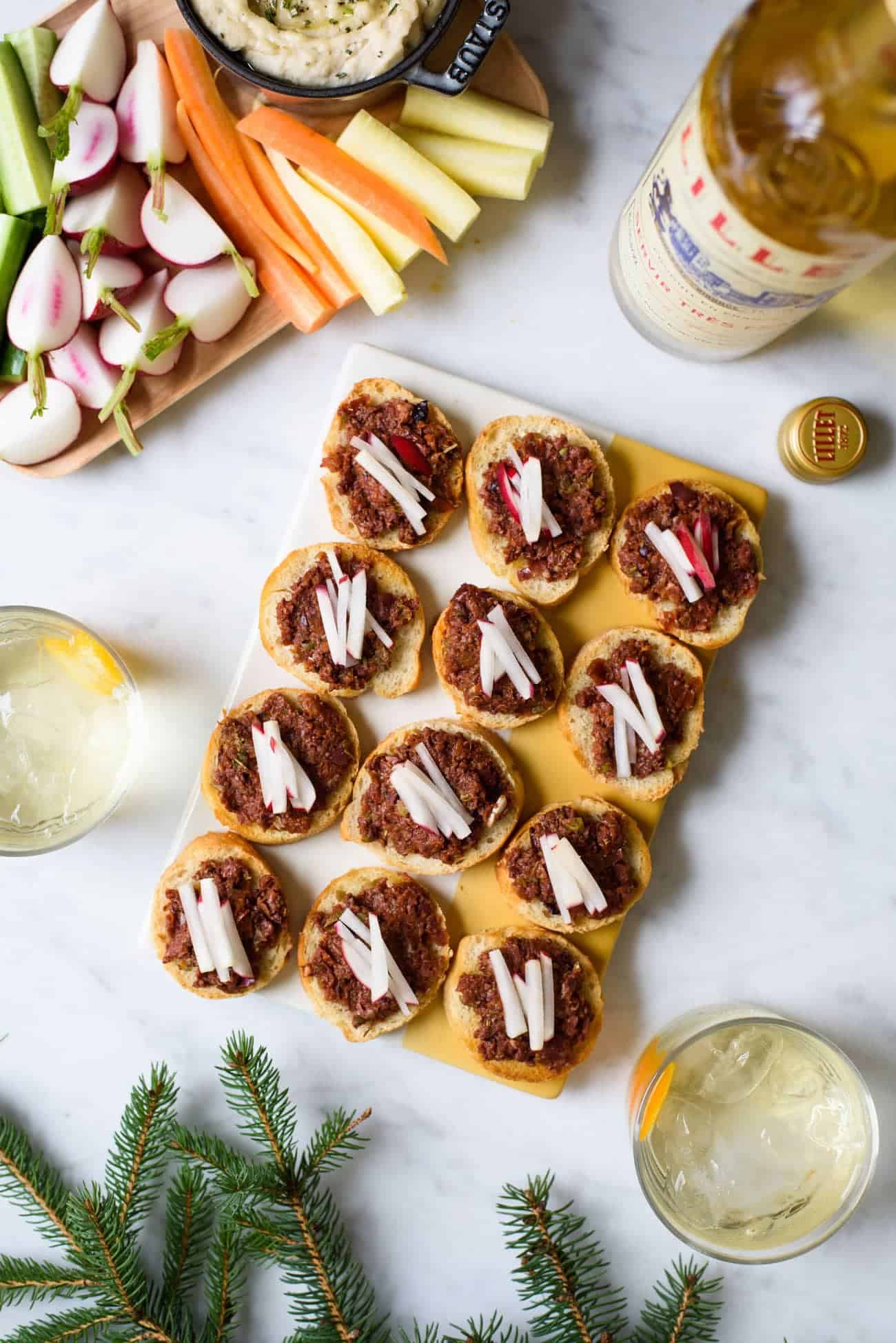 Sun-dried tomato tapenade on crostini with radish matchsticks, served with Lillet Blanc