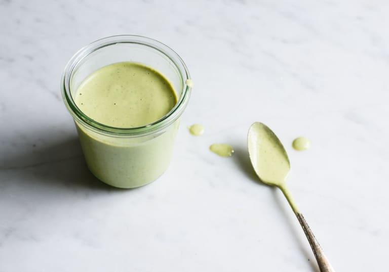 Creamy cilantro-lime tahini dressing in a Weck jar with a teaspoon
