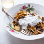 Azerbaijani cuisine: Khingal (handmade noodles) | Noodles with mushrooms and caramelized onions on a floral plate on a white tablecloth