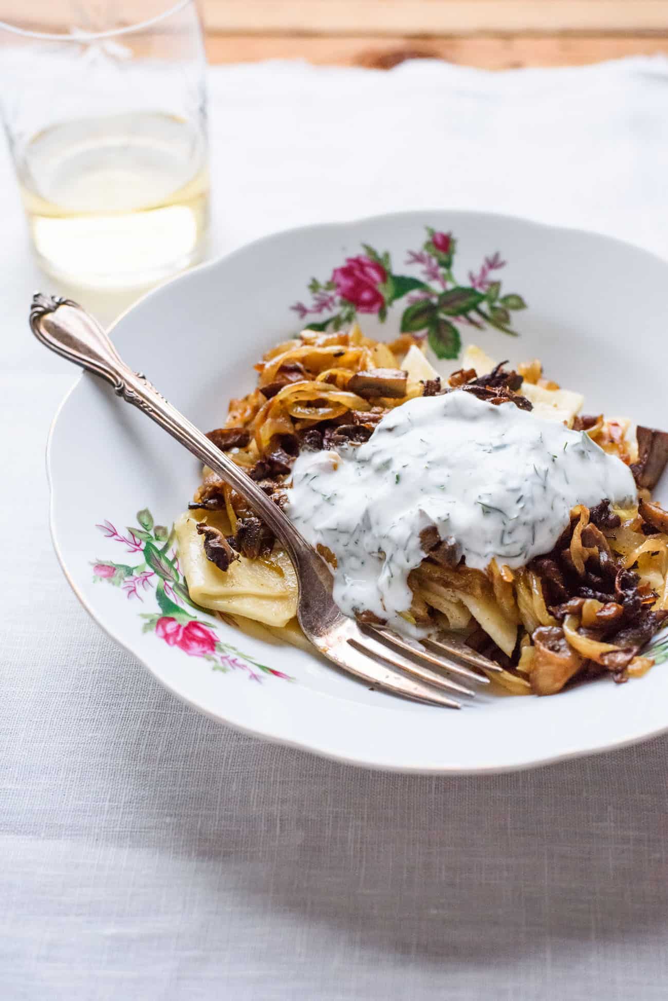 Azerbaijani cuisine: Khingal (handmade noodles) | Noodles with mushrooms and caramelized onions on a floral plate on a white tablecloth