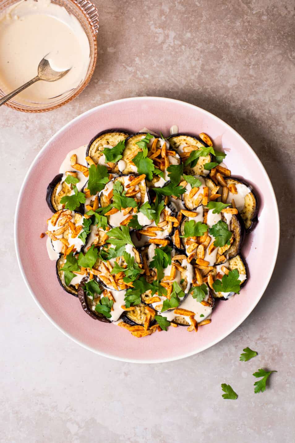 How to roast eggplant | Ottolenghi-inspired roasted eggplant rounds with tahini sauce on a pink platter