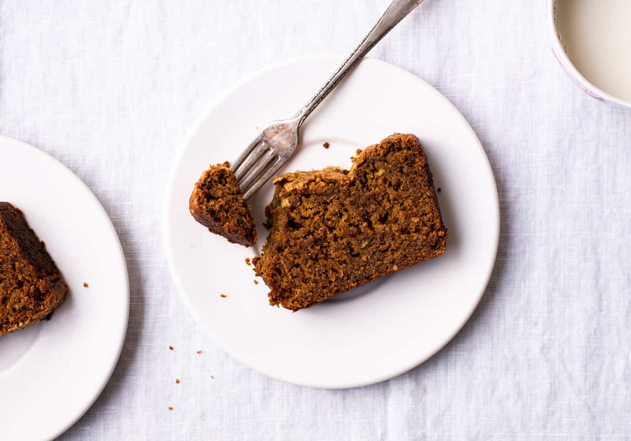 Slices of gingerbread loaf cake on white plates on a white tablecloth