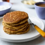 Stack of vegan cornmeal pancakes on a white plate
