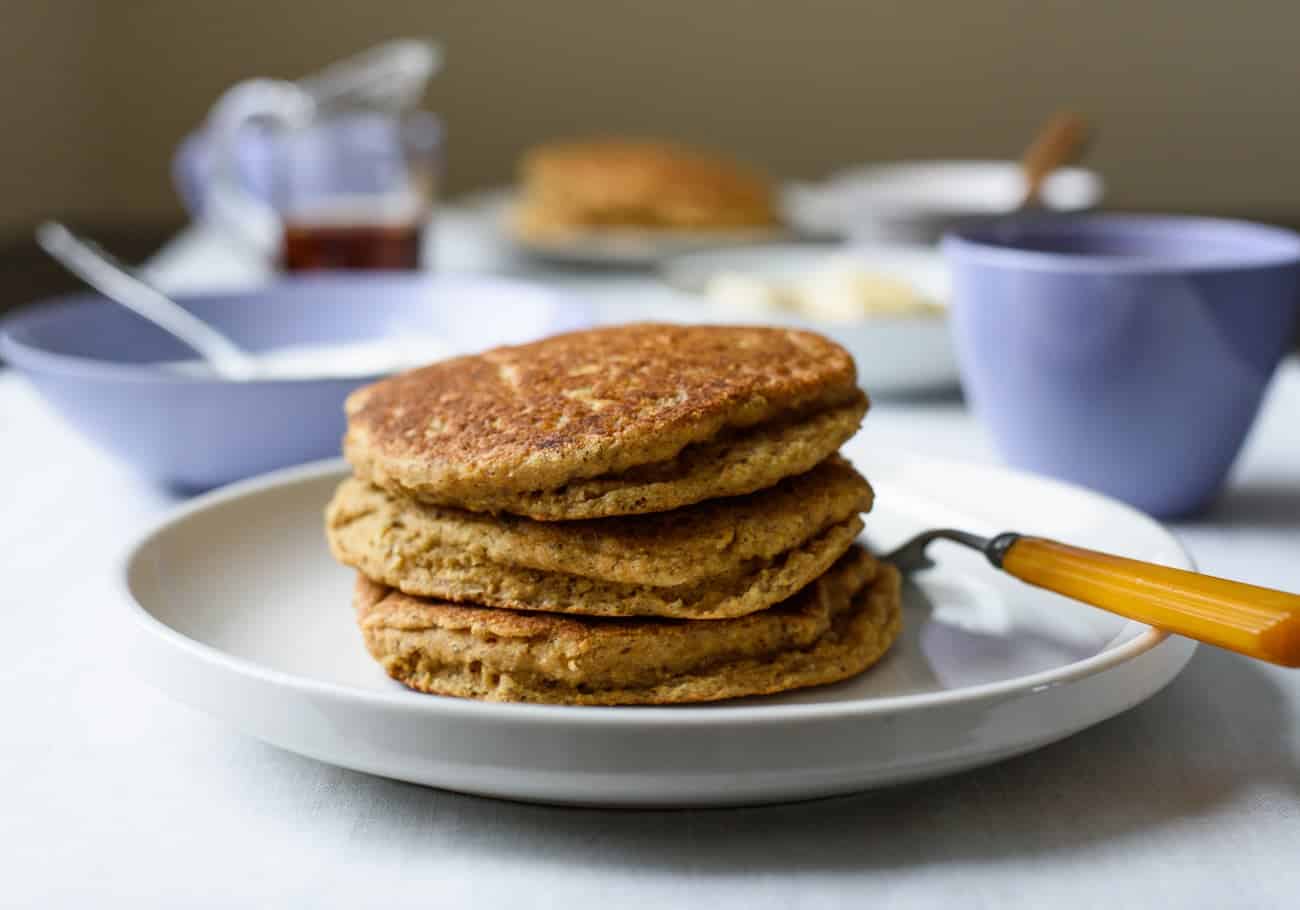 Stack of vegan cornmeal pancakes on a white plate