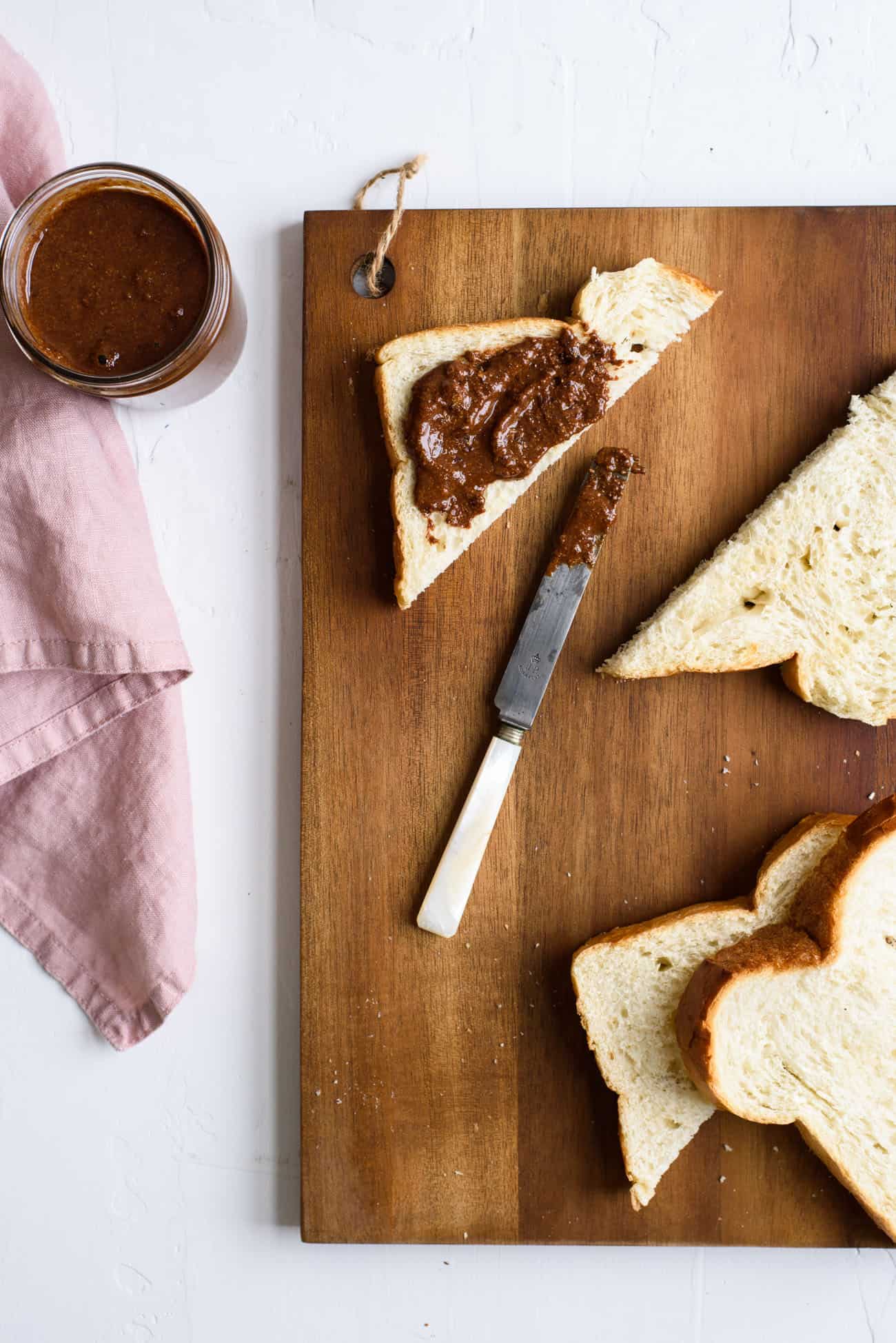 Homemade chocolate hazelnut spread (DIY Nutella) on toast on a wooden cutting board