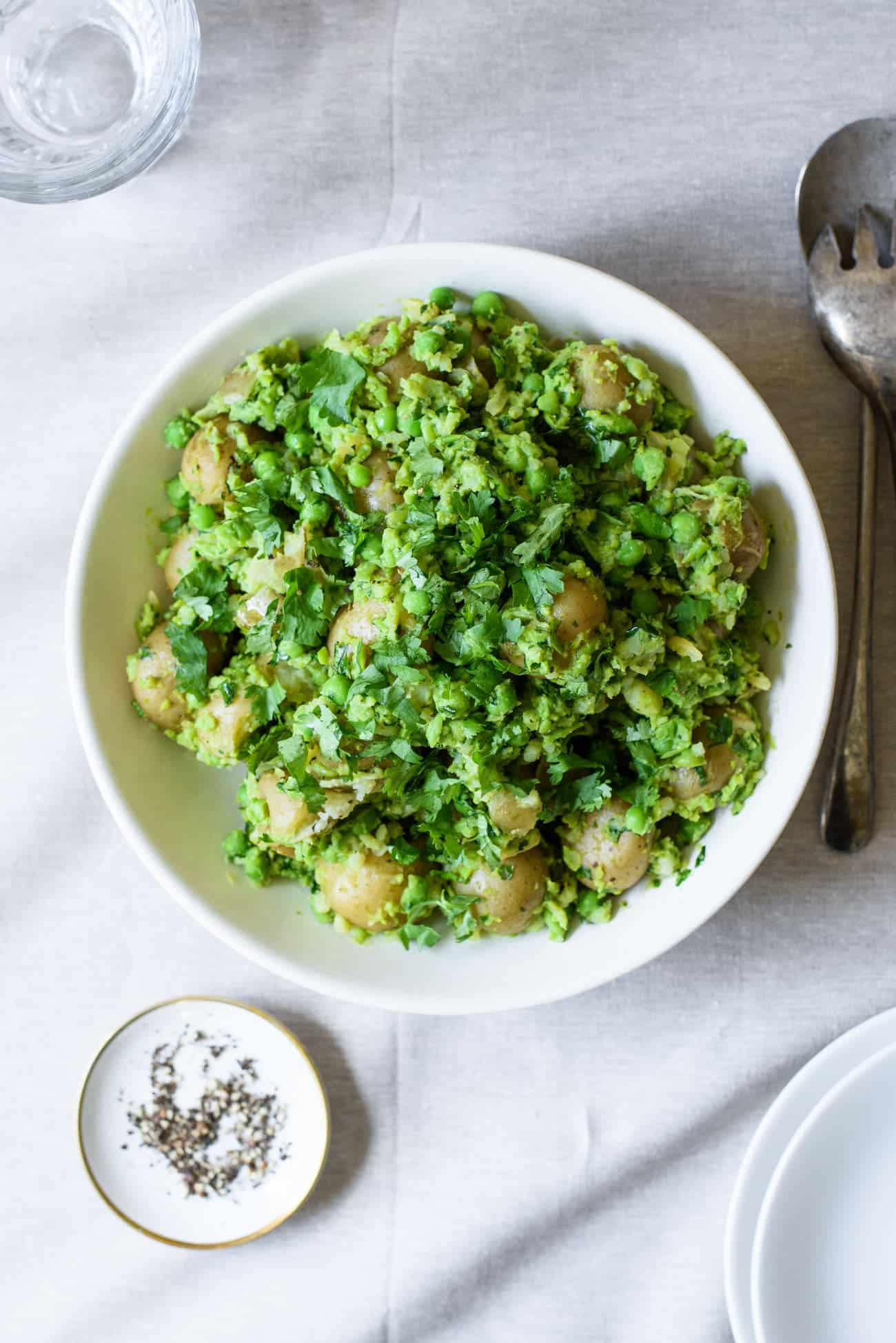 Bowl of smashed new potatoes with peas