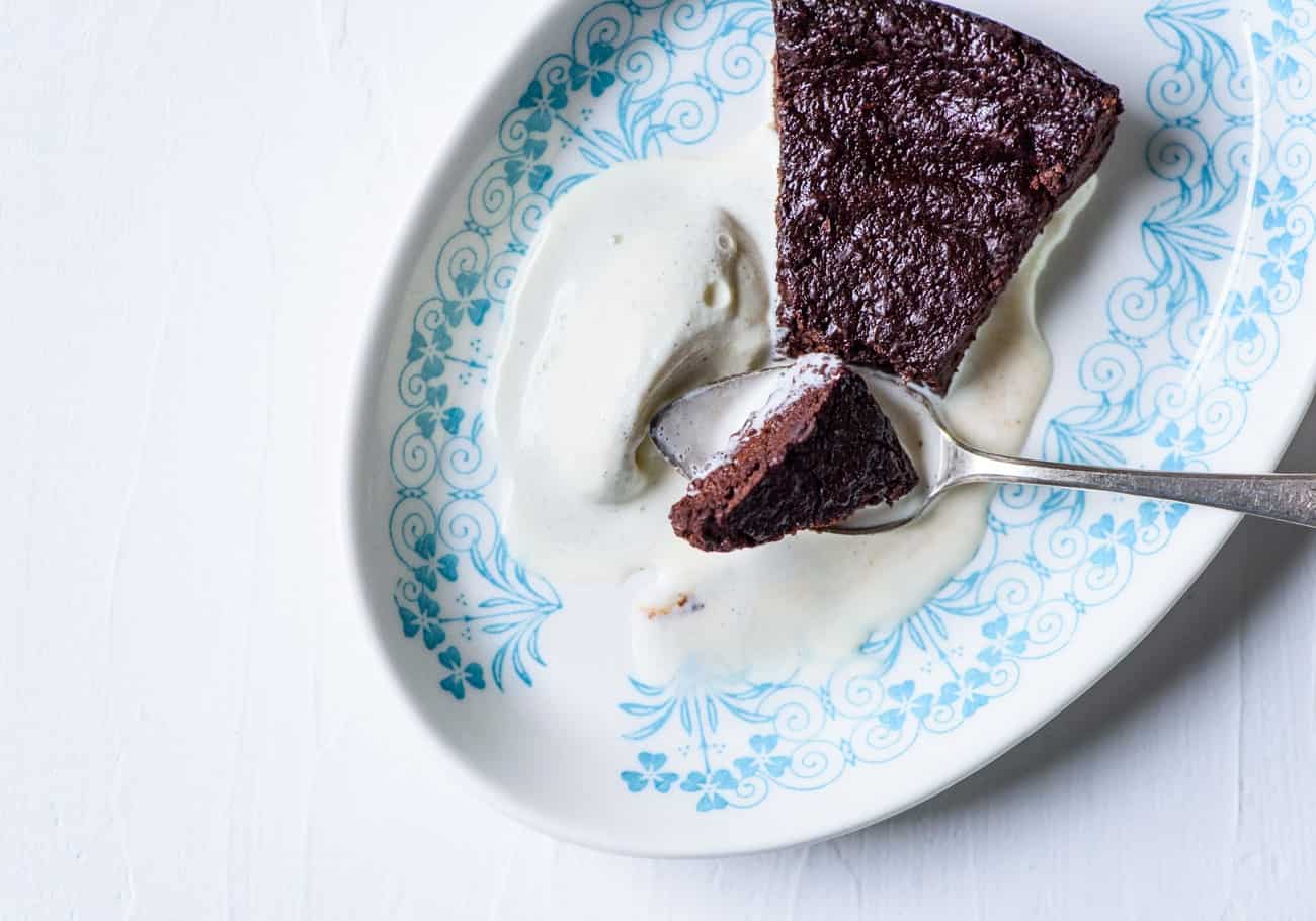 Slice of flourless chocolate cake with scoop of vanilla ice cream