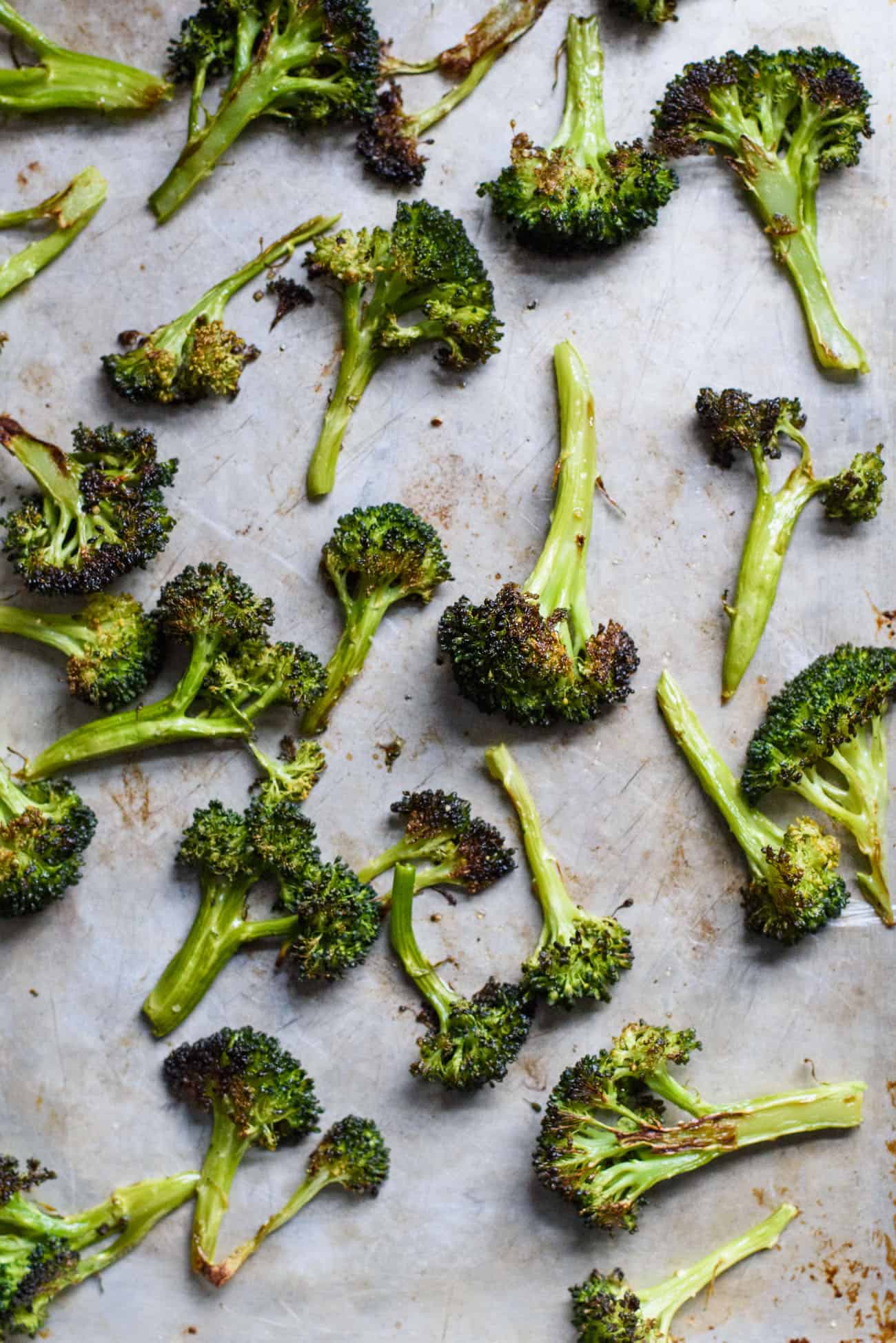 Crispy roasted broccoli on a baking sheet for plant-based meal prep