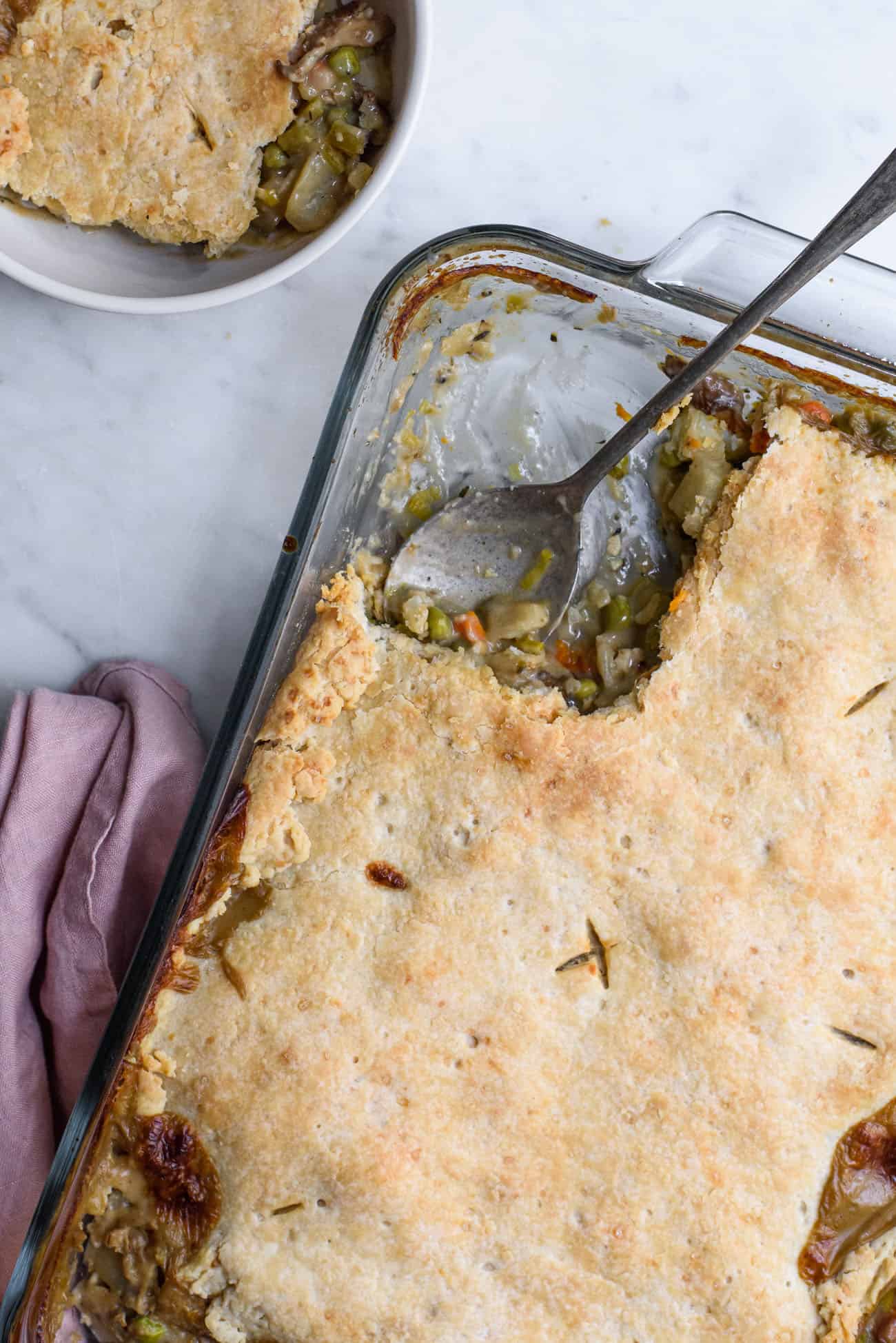 Vegan pot pie in a glass Pyrex dish with a metal spoon