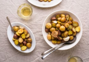 Bowl of garlic rosemary roasted potatoes on beige tablecloth