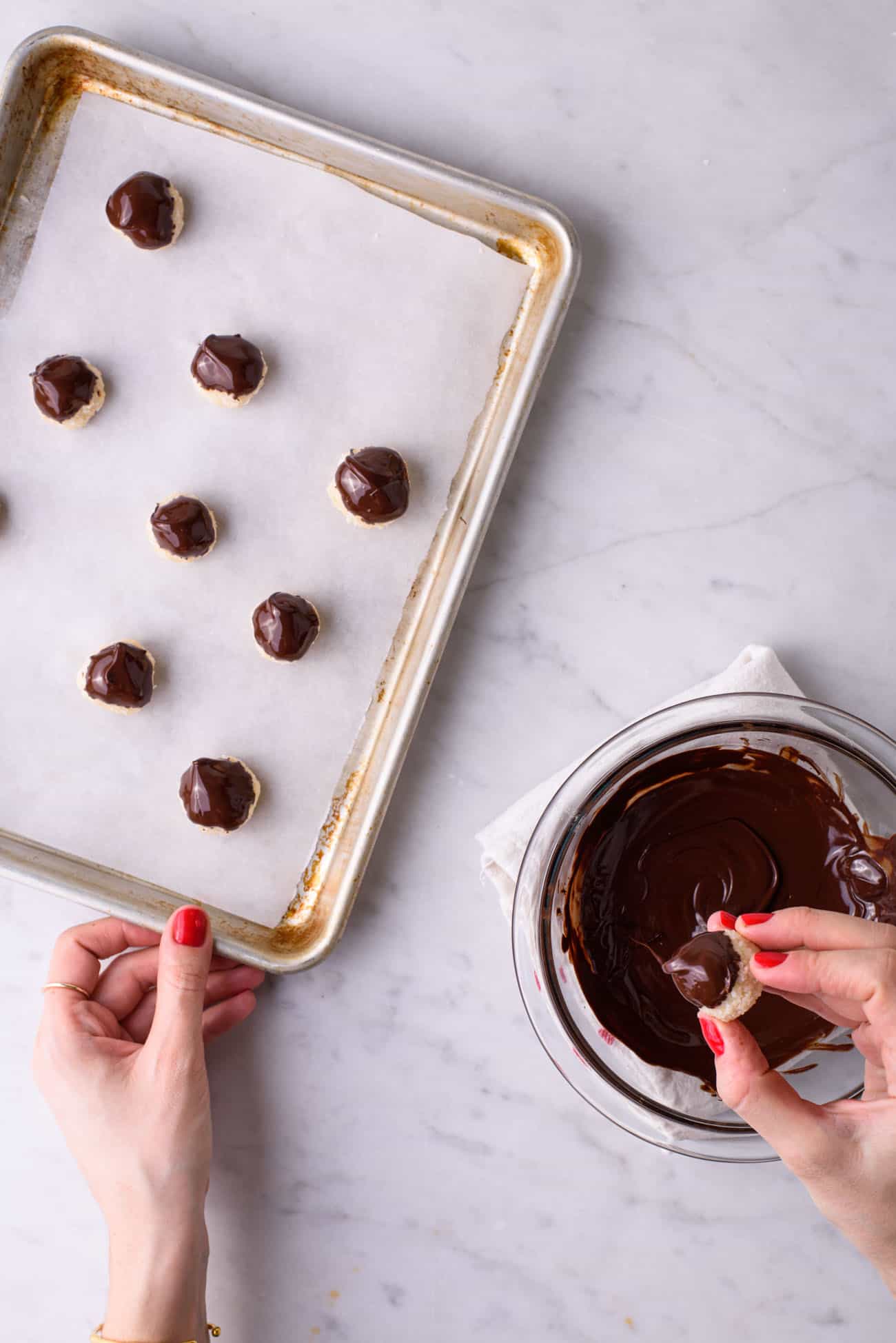Woman's hands dipping coconut balls into melted chocolate