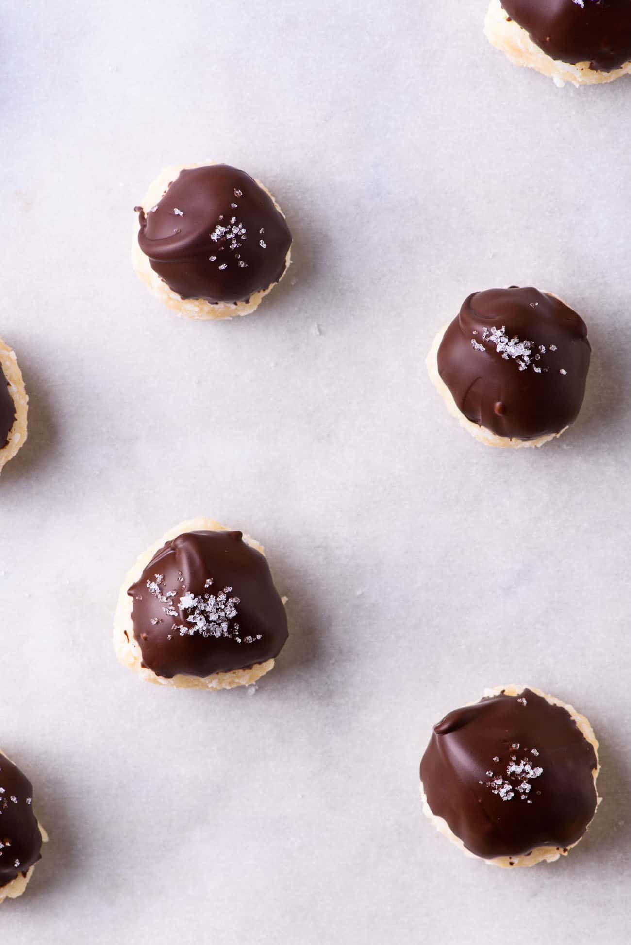 Coconut chocolate balls with sea salt on parchment paper
