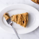 Slice of vegan cookie cake on a white oval plate