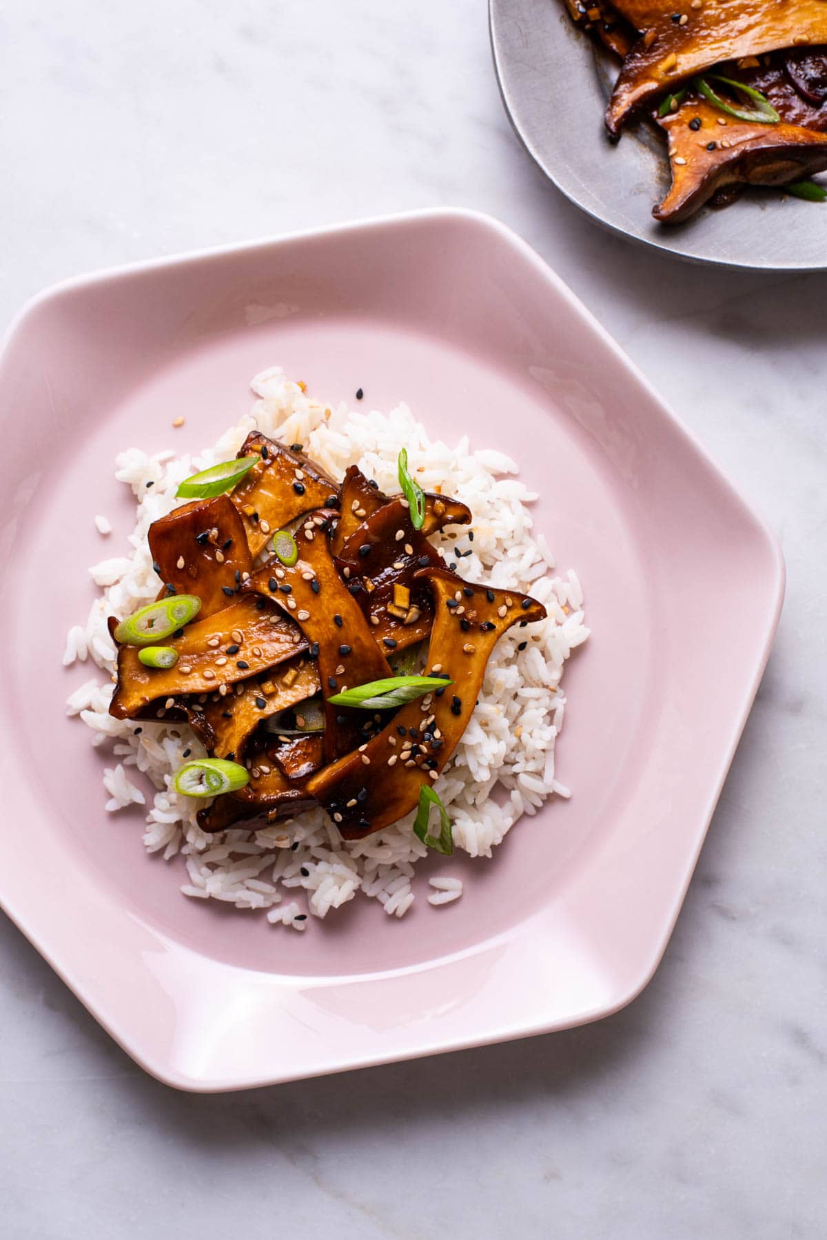 Soy-glazed trumpet mushrooms on white rice with scallions.