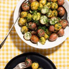 Ukrainian dill potatoes on a white oval platter on a yellow gingham tablecloth