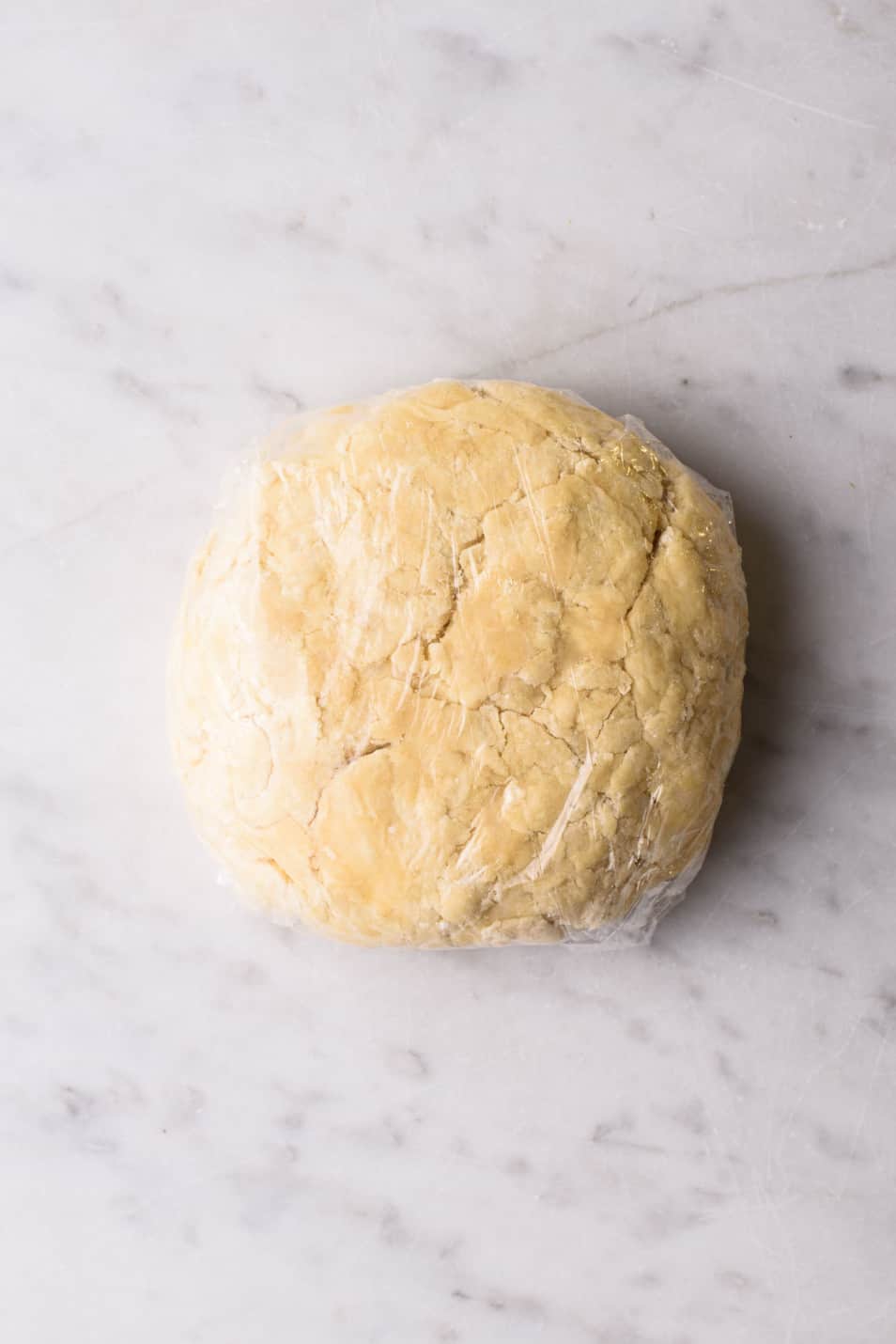 Ball of vegan pastry dough wrapped in plastic