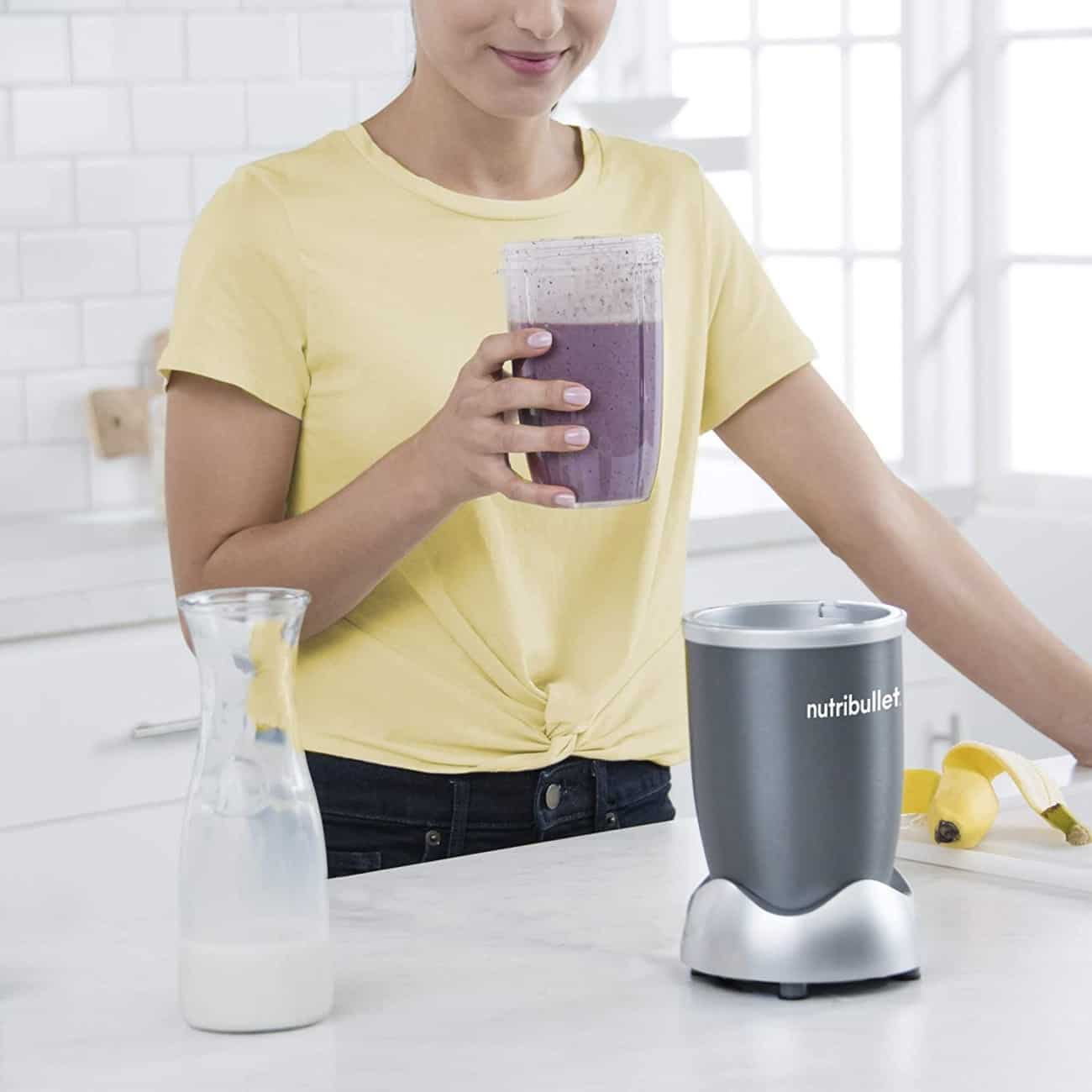Woman drinking blueberry smoothie from Nutribullet cup