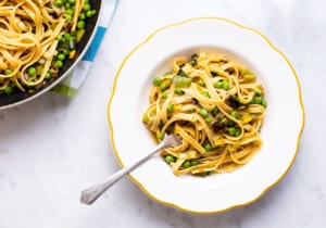 Vegan pasta with leeks and peas in a vintage scalloped bowl