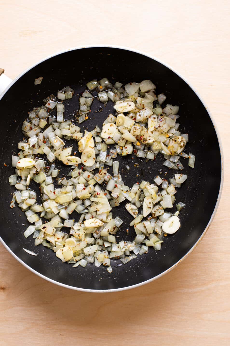 Diced sautéed white onion in a skillet.