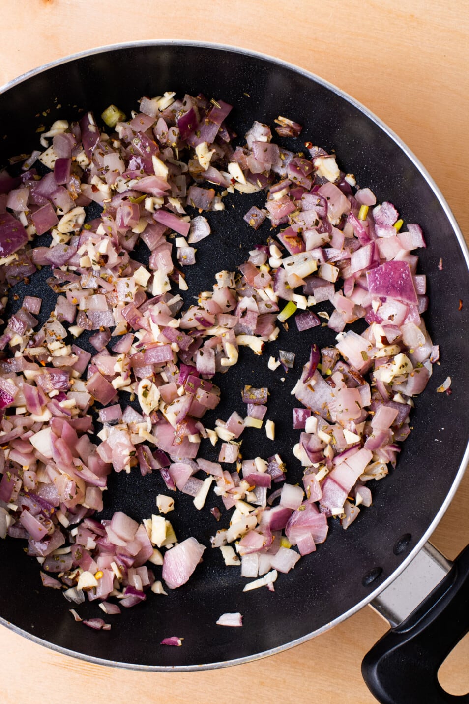 Sauteed red onions and garlic in a pan.