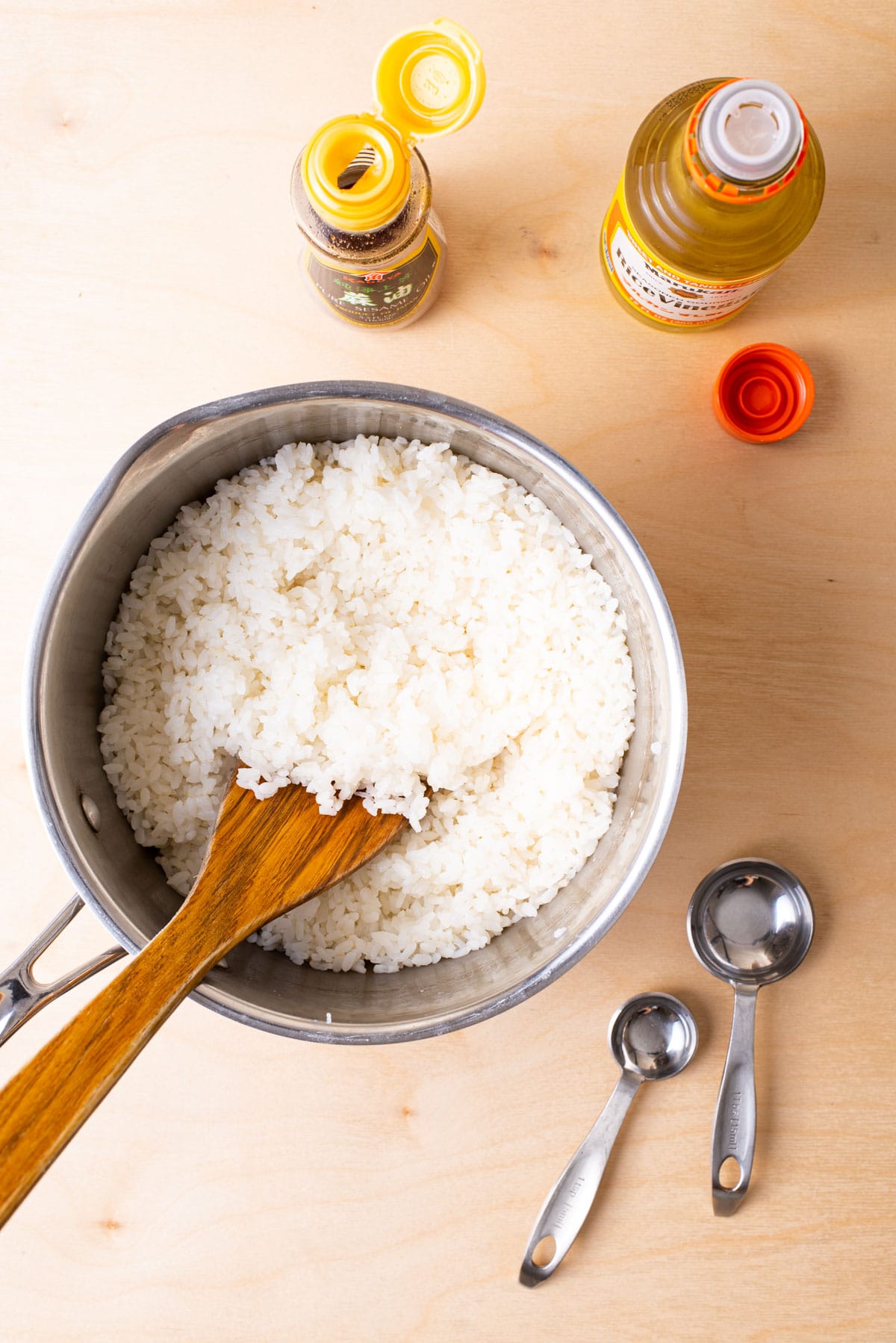 Seasoning cooked rice with rice vinegar and sesame oil.