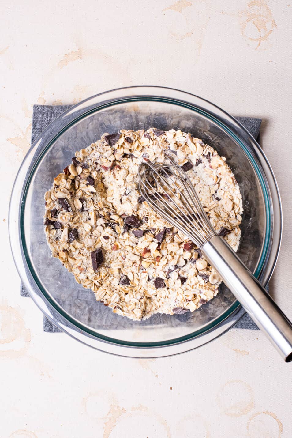 Oats, almond flour, chocolate chunks, and hazelnuts whisked together in a bowl.