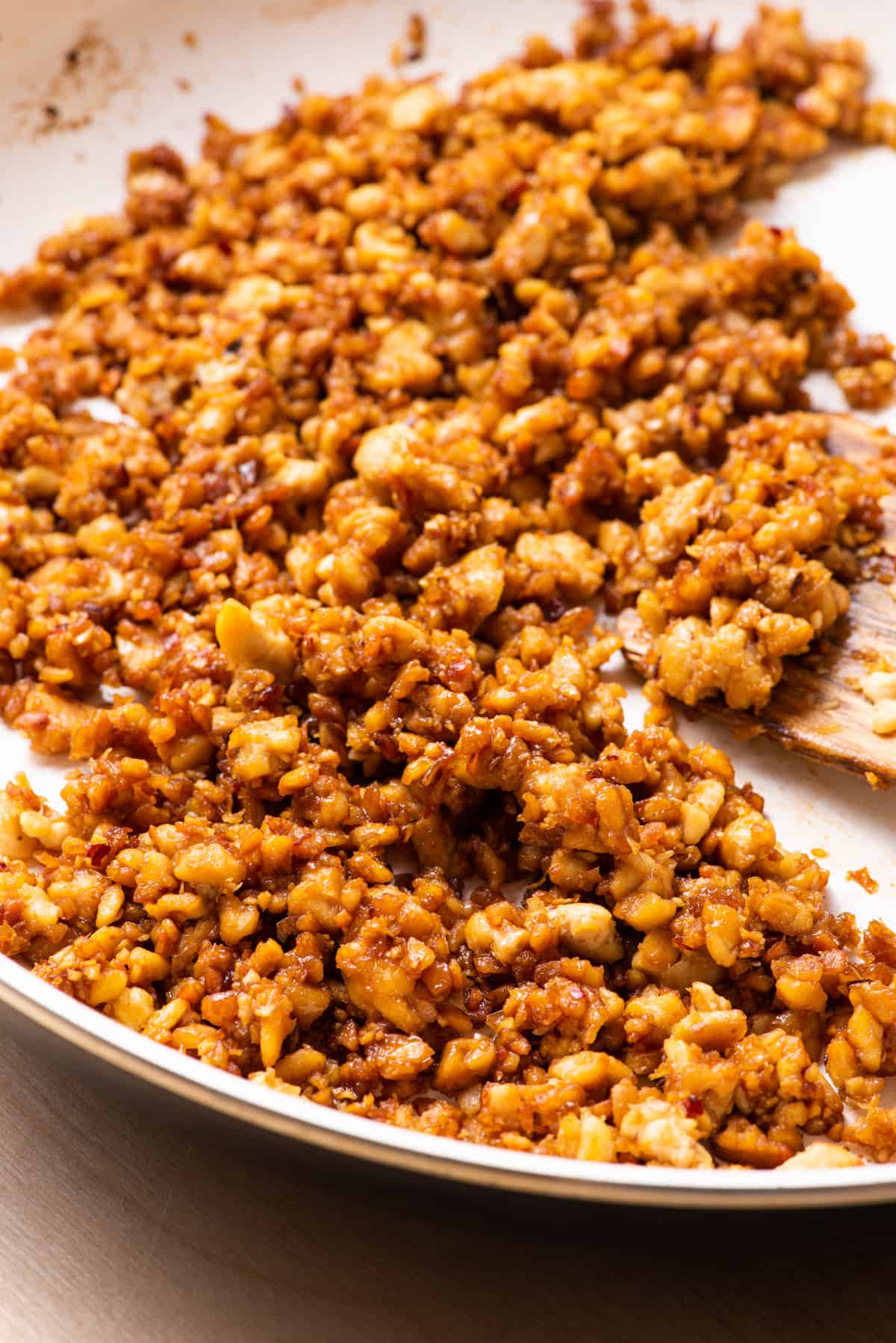 Glazed tempeh crumbles in a skillet.