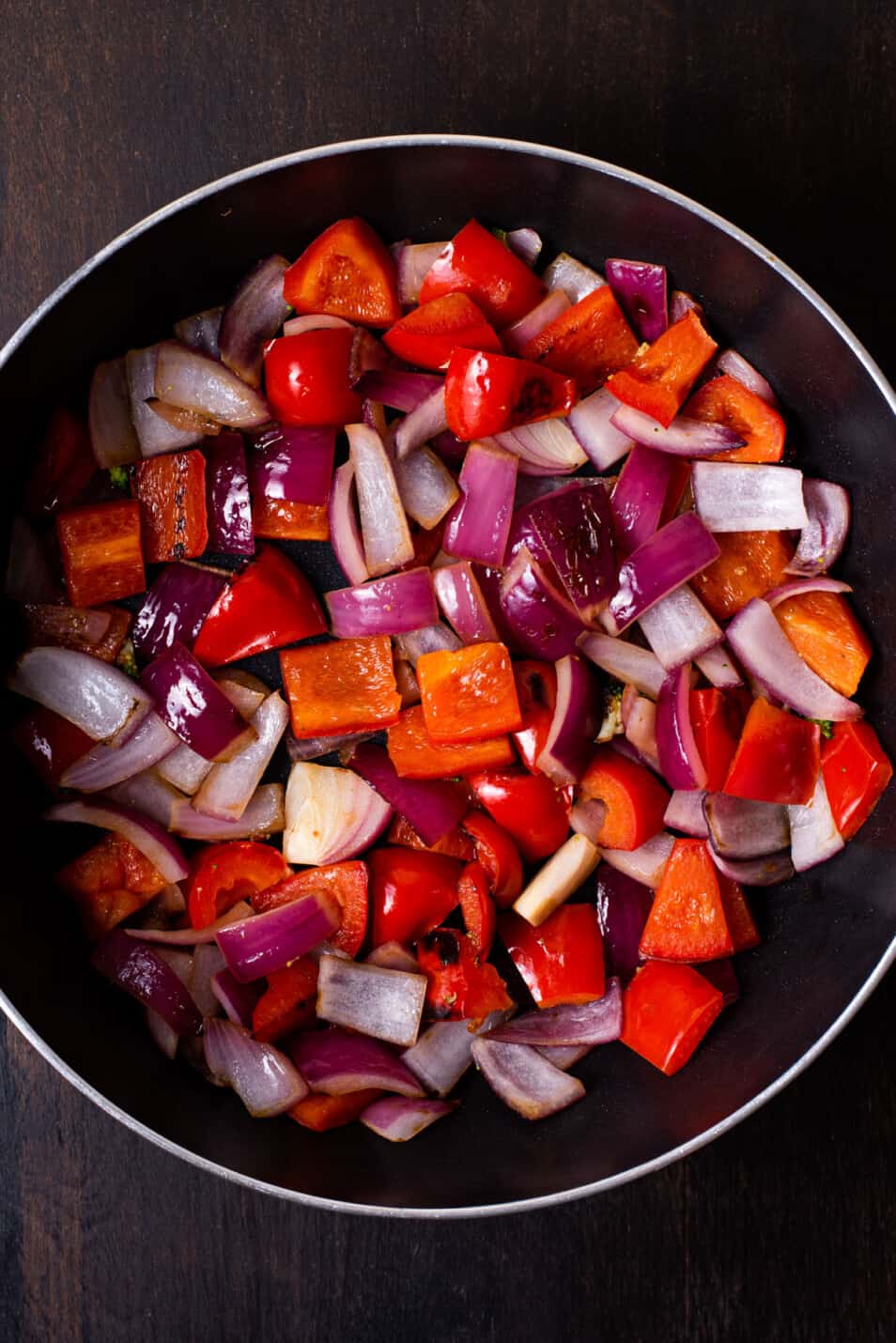 Browned onions and peppers in a saucepan.