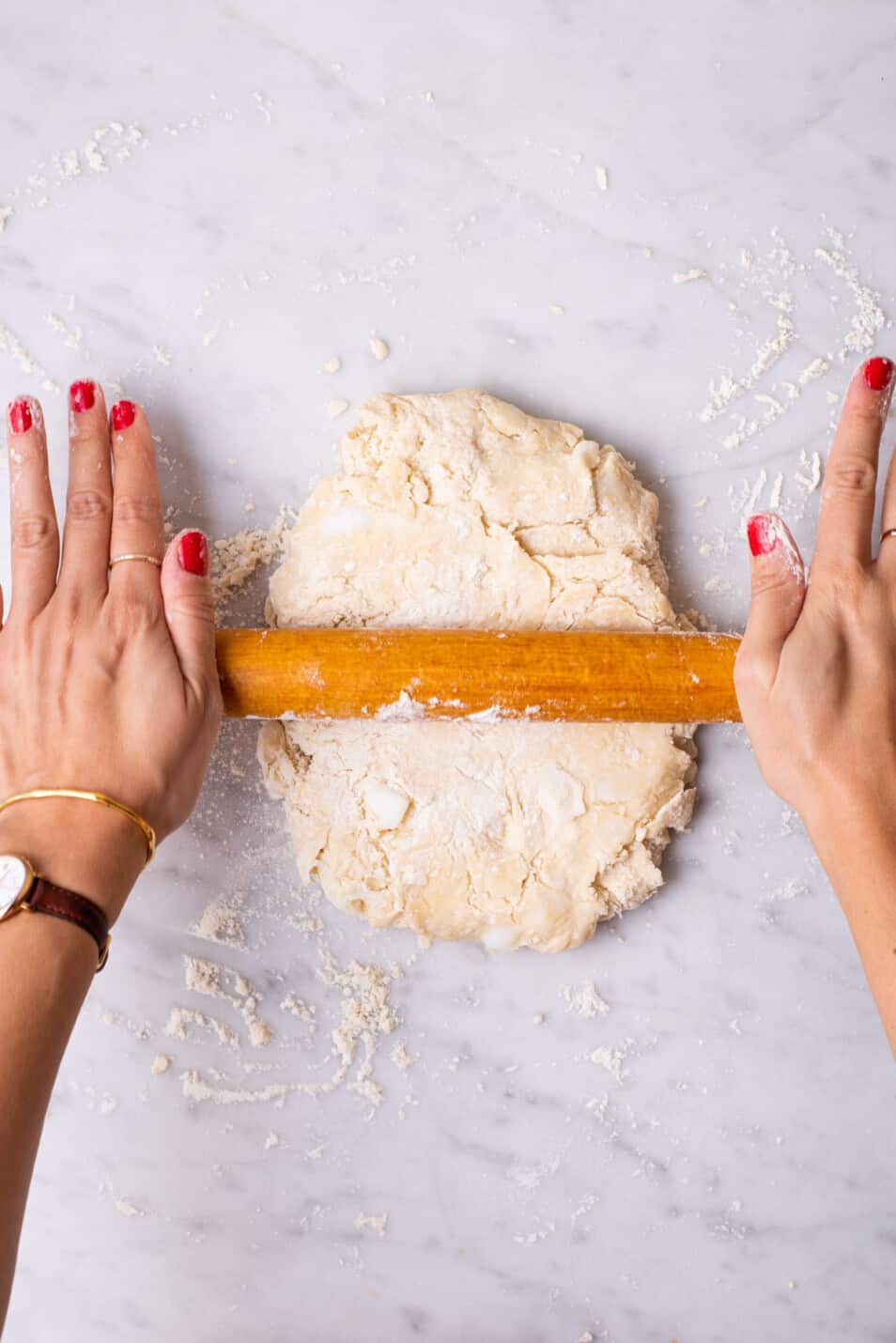 Woman's hands rolling out dough.