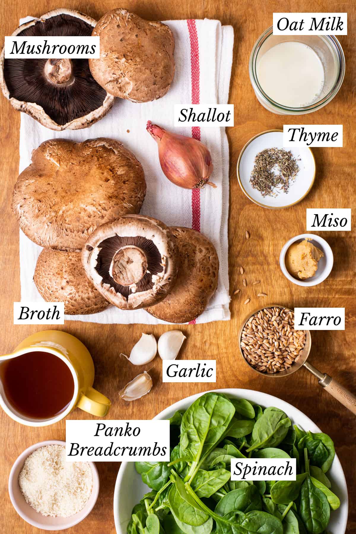 Ingredients gathered on a wooden table to make vegan stuffed portobello mushrooms.