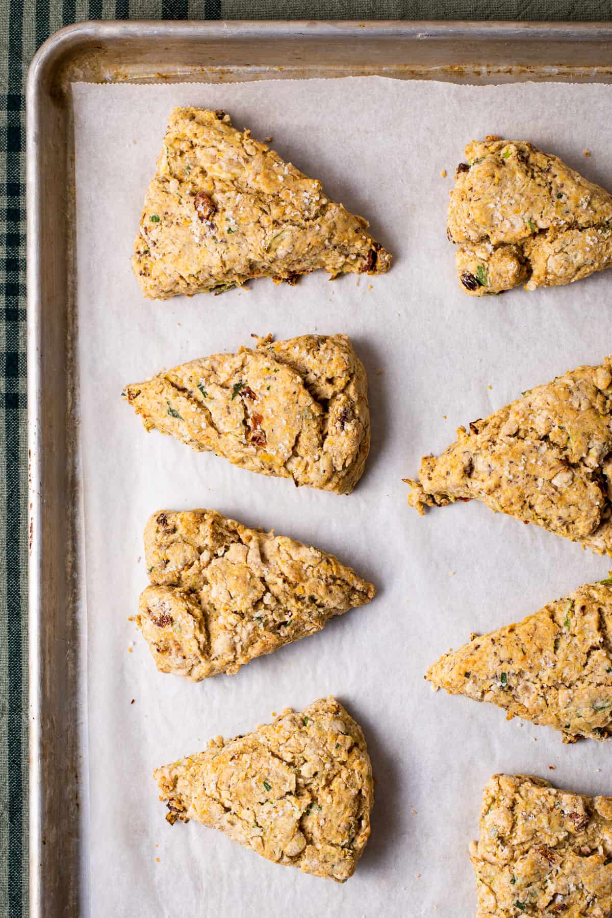 Savory vegan scones on a baking sheet with parchment paper.