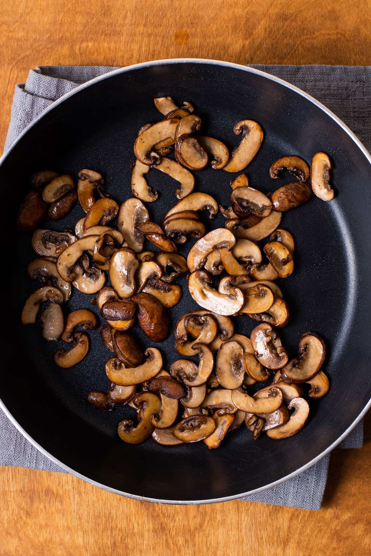 Browned cremini mushrooms in a saucepan.