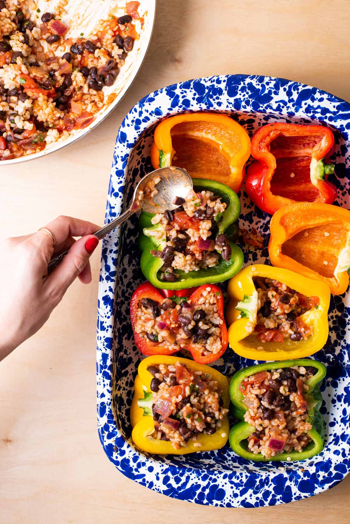 Filling multicolored bell peppers with Mexican rice filling.