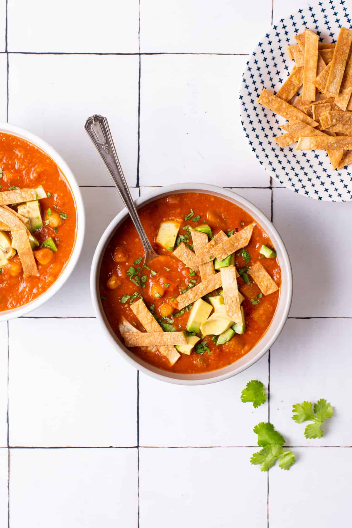 Mexican-inspired tomato chickpea soup with tortilla crisps and cilantro.