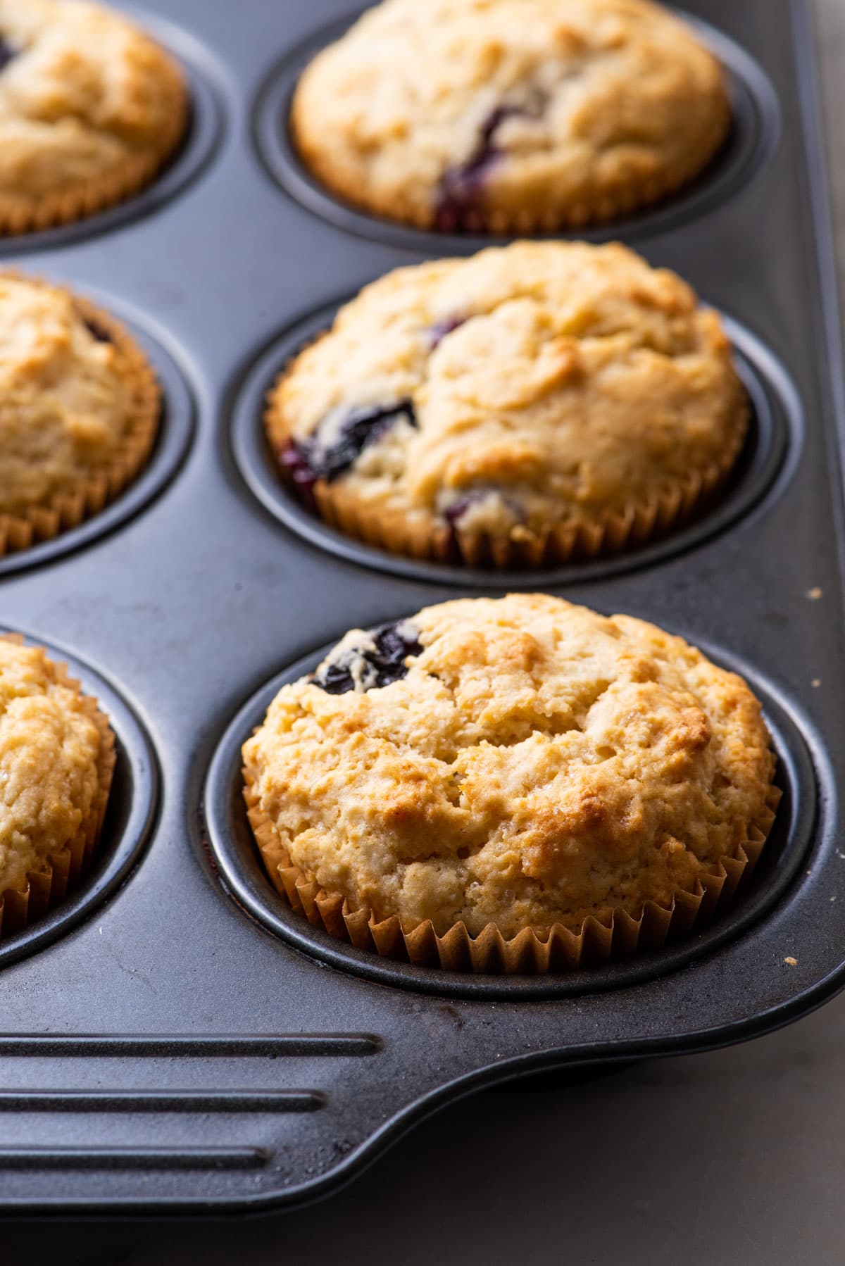Vegan blueberry lemon muffins in a muffin tin.
