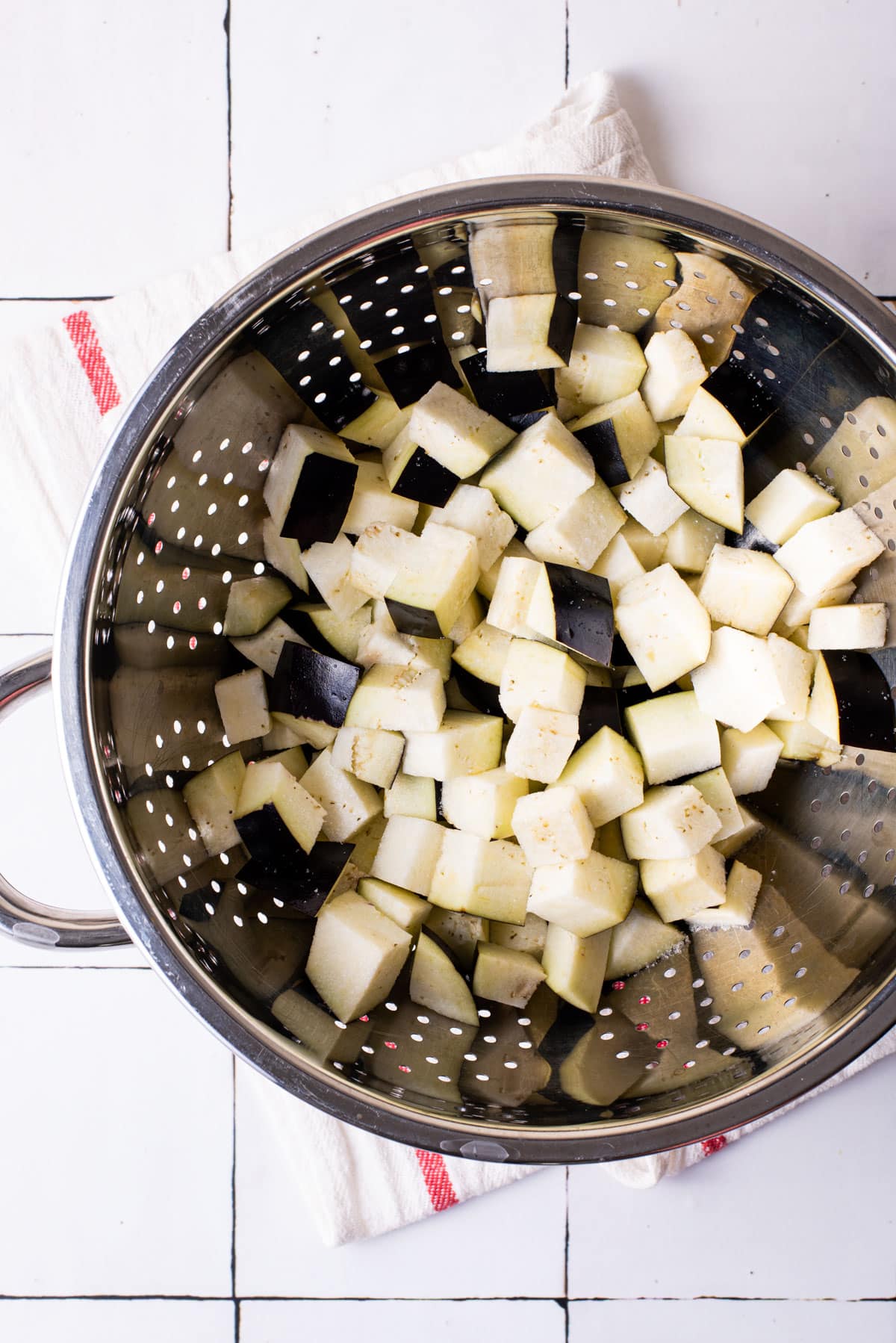 Salted eggplant cubes in a colander.