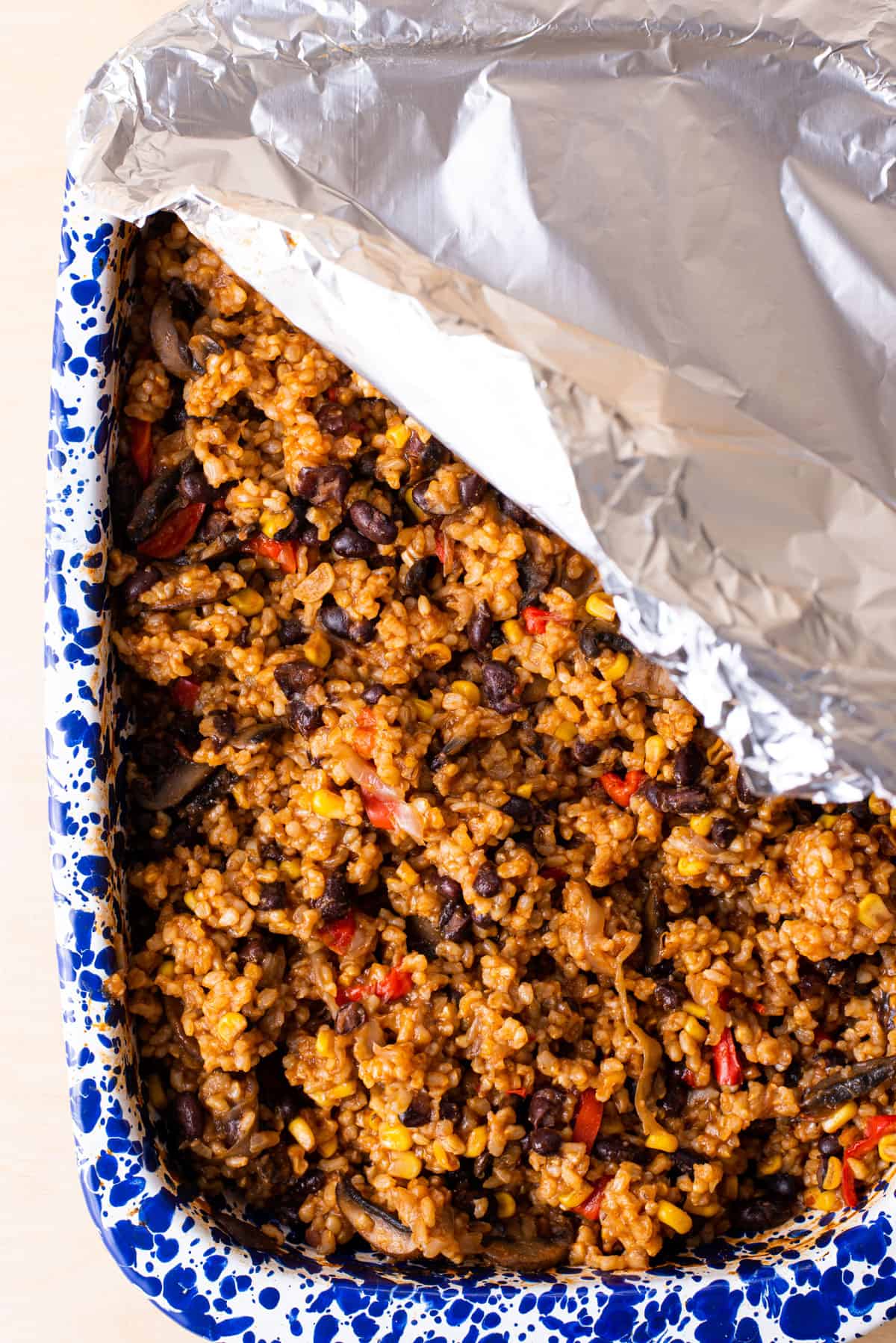 Baked rice and beans casserole covered with foil.