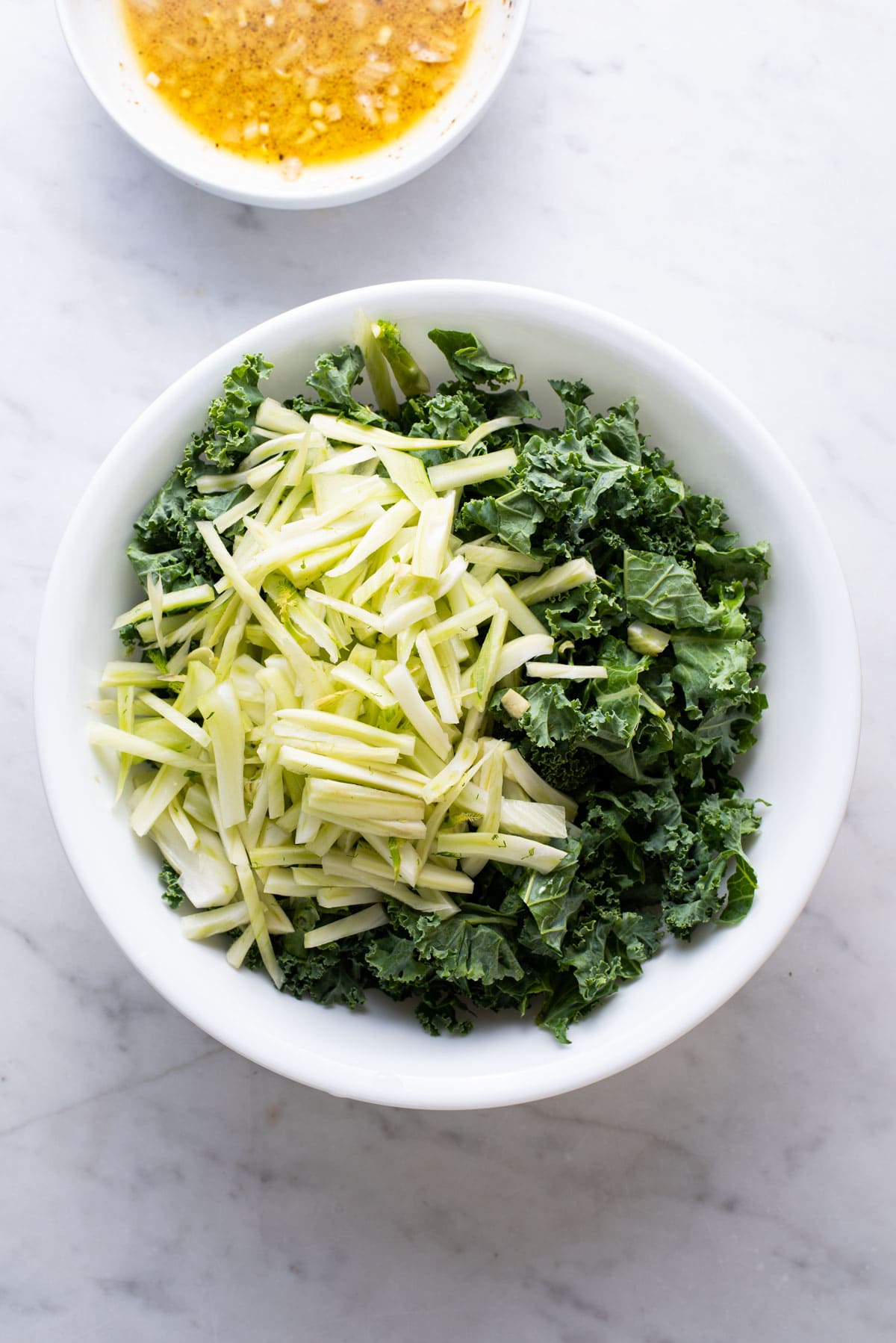 Chopped kale and fennel in a white bowl.