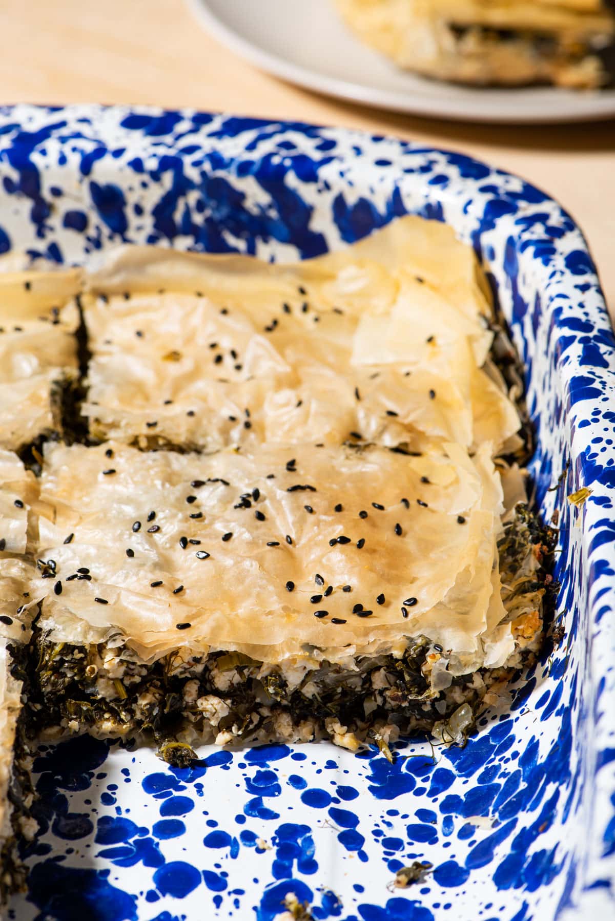 Vegan Greek spinach pie with tofu in a blue speckled casserole dish.