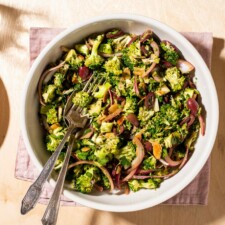 Raw broccoli salad in a beige bowl.