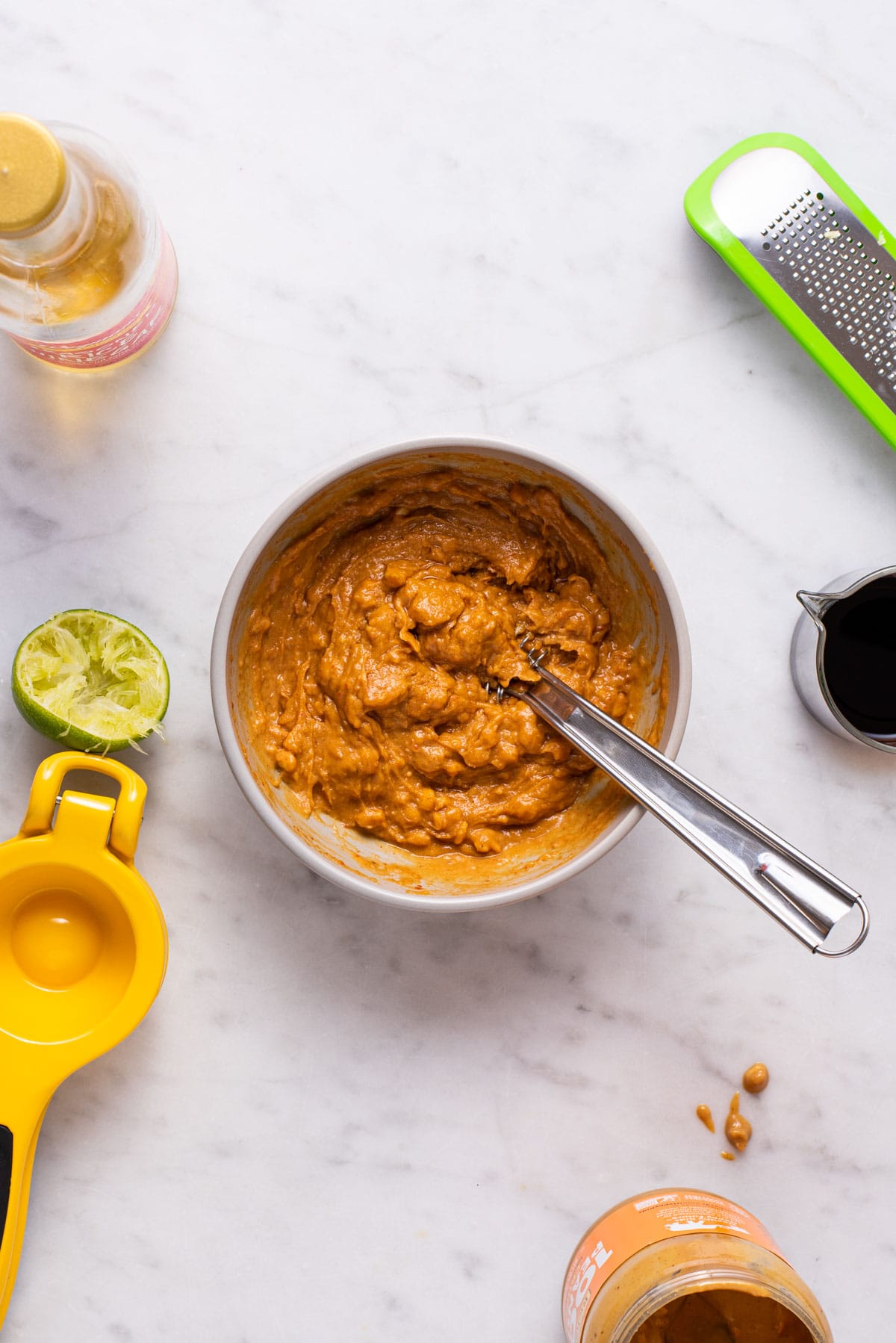 Whisking peanut sauce in a bowl.