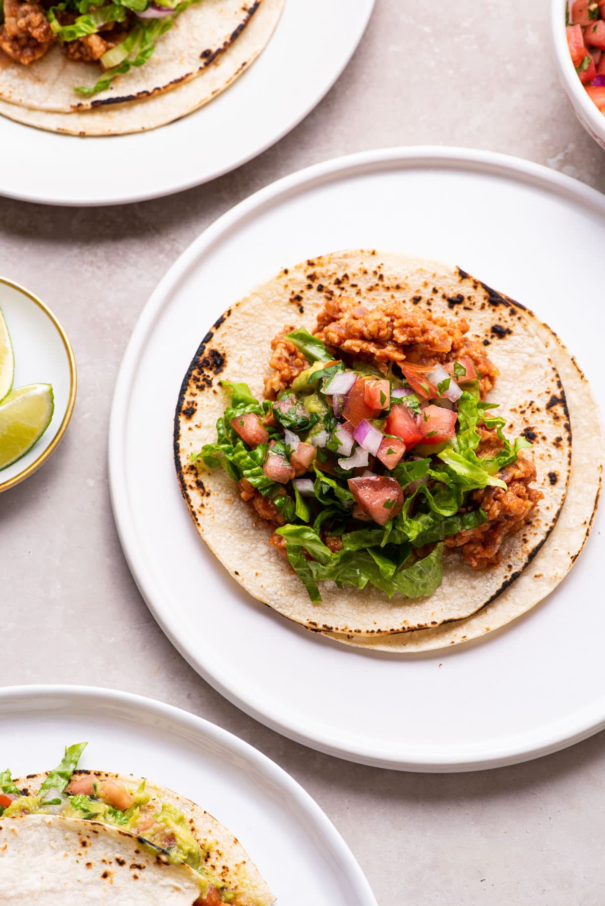 Vegan tempeh tacos on white plates.