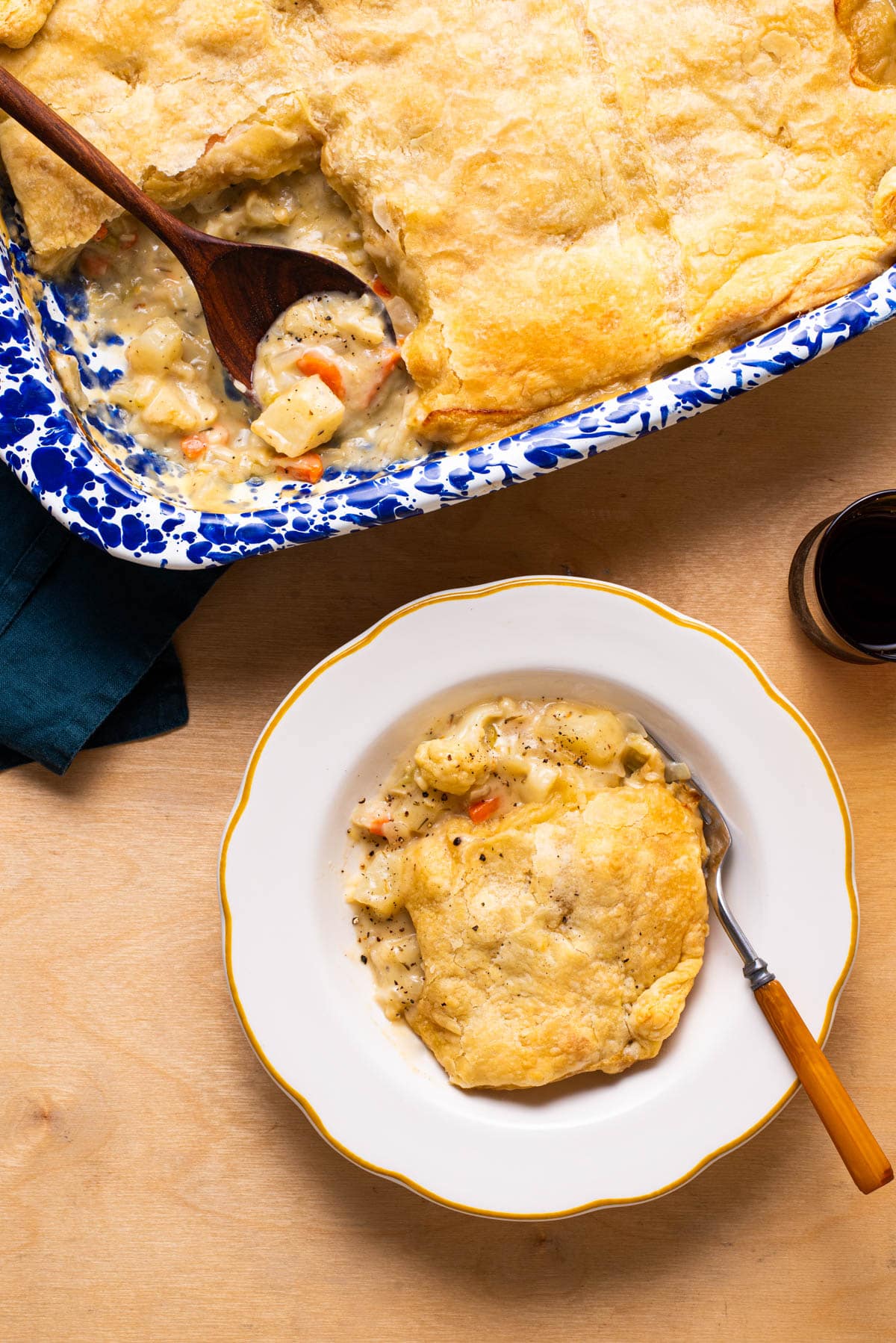 Vegan cauliflower pot pie with a puff pastry topping served in a vintage scalloped plate.