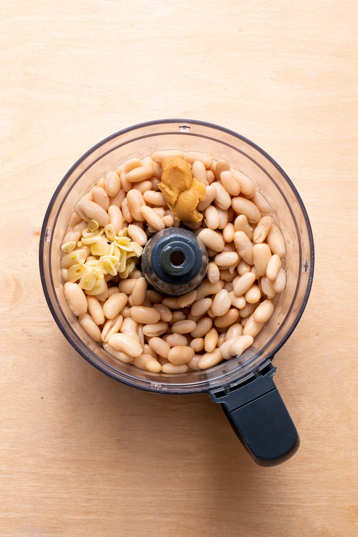 White beans, garlic, and miso in a food processor.
