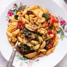 Cavatelli pasta with beans, mushrooms, kale, and tomatoes.