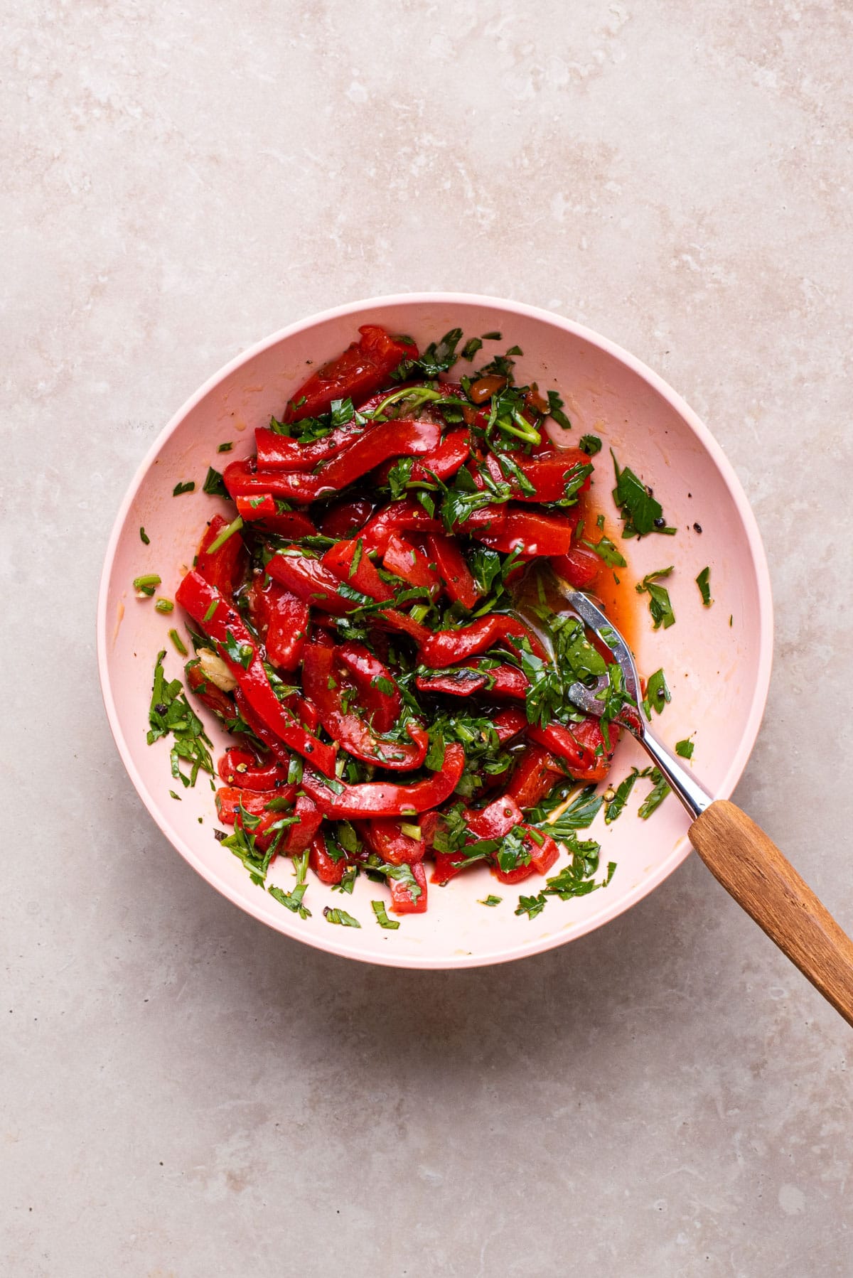Roasted red pepper and parsley relish in a pink bowl.