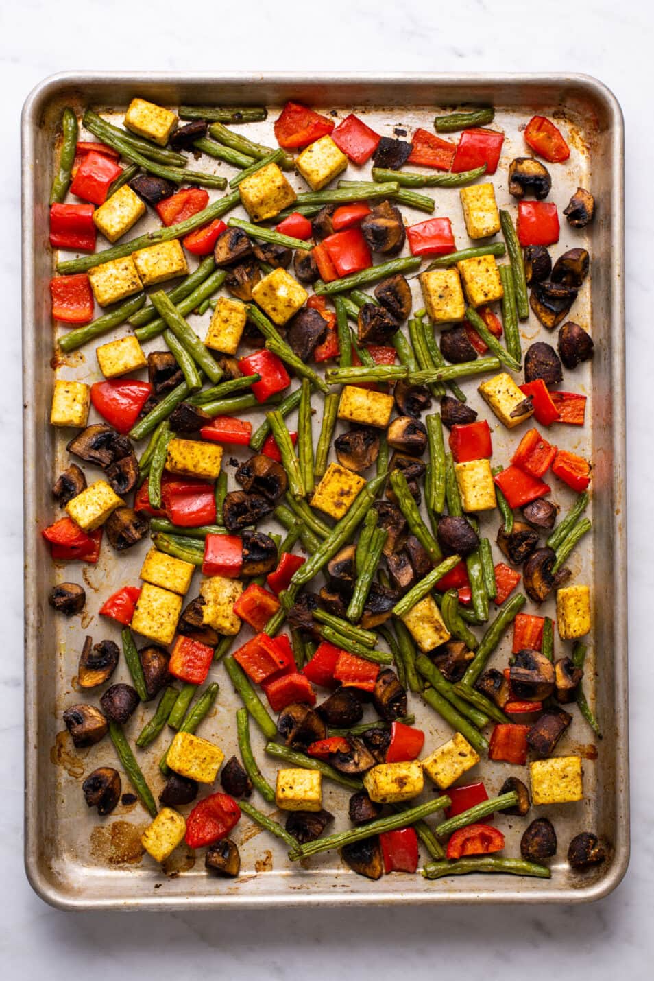 Roasted tofu and vegetables on a sheet tray.