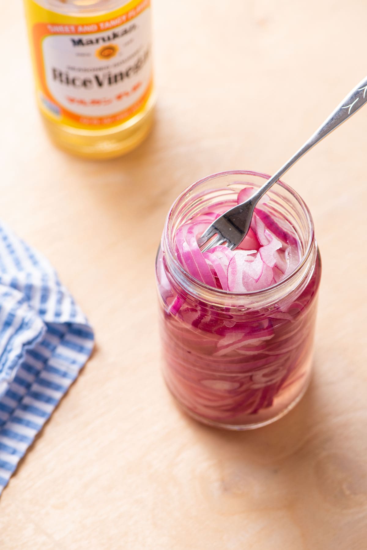 No-cook quick-pickled red onions in a jar with a fork.