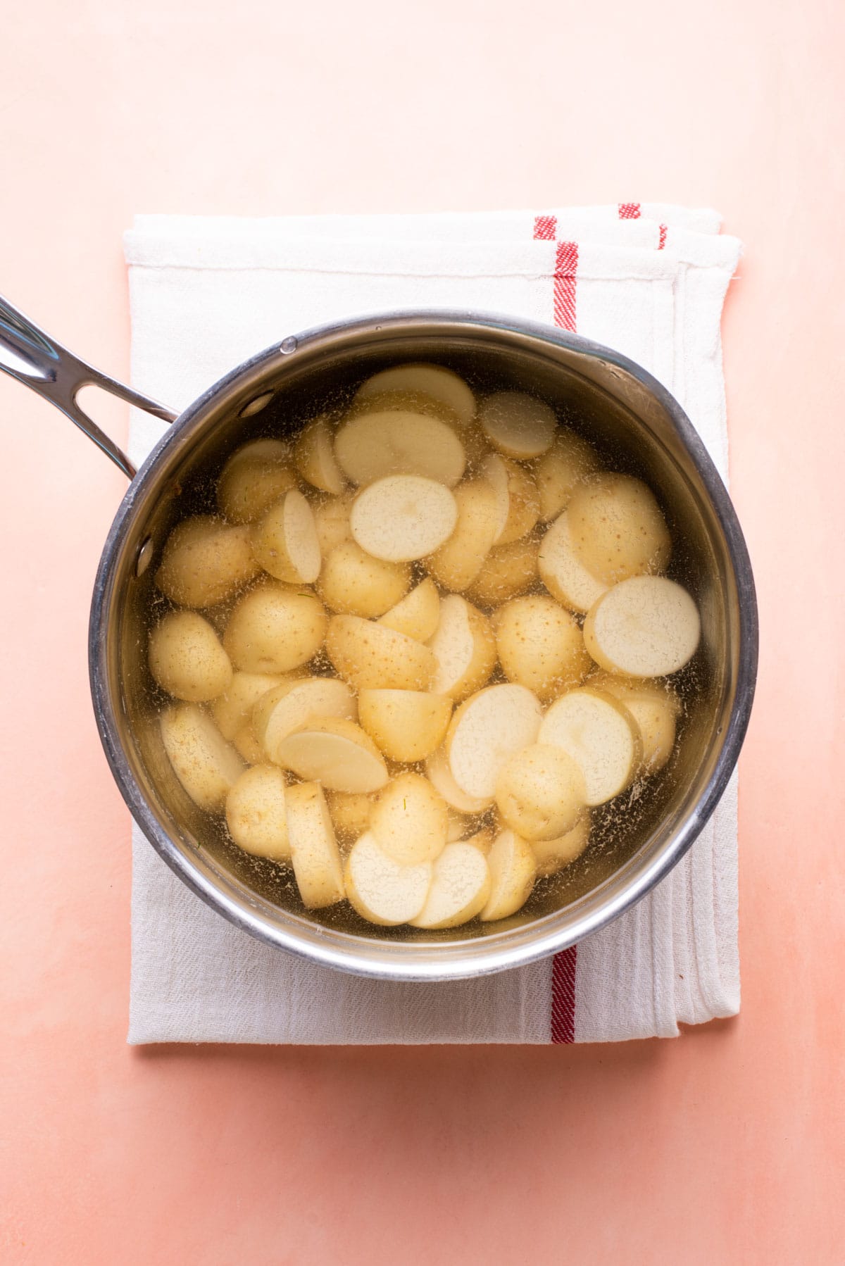 Baby potatoes in a pot of water, ready to be boiled.